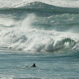 A watchful Surfer ready to duck under the oncoming wave.